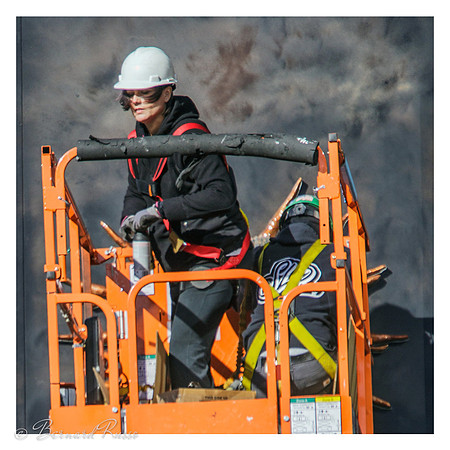 Femme casquée sur grue élevatrice