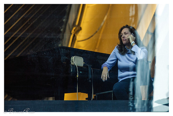 Femme téléphonant appuyée sur un piano